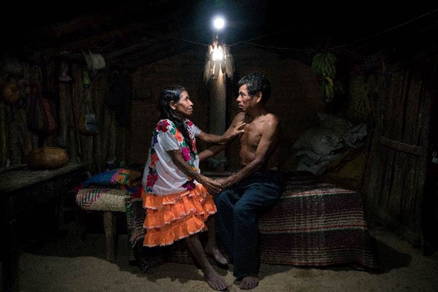Een man en een vrouw zittend op bed bij het licht van een zonnelamp